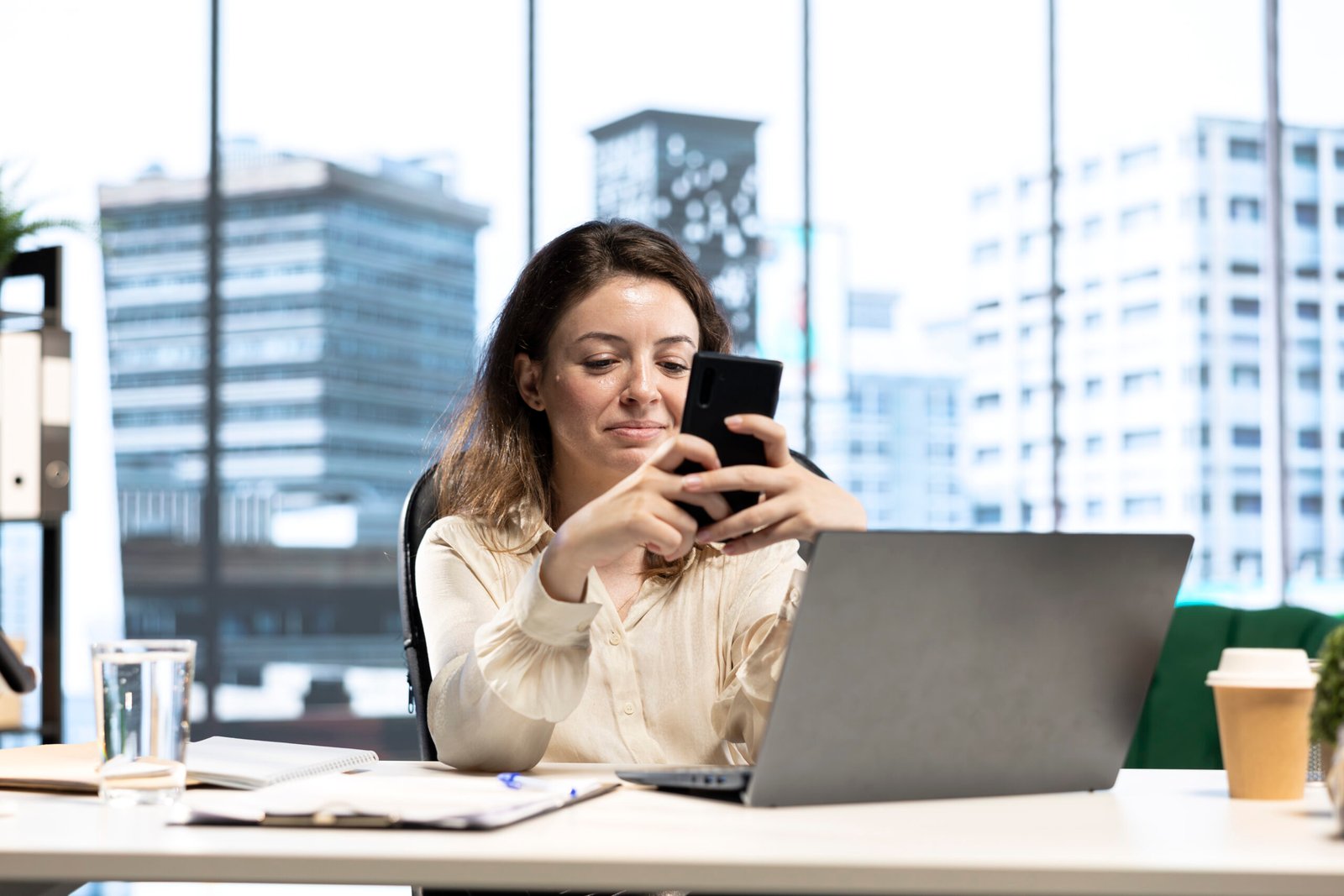 Jovem empresária utilizando Wi-Fi corporativo rápido e seguro no trabalho, garantindo produtividade e comunicação eficiente.